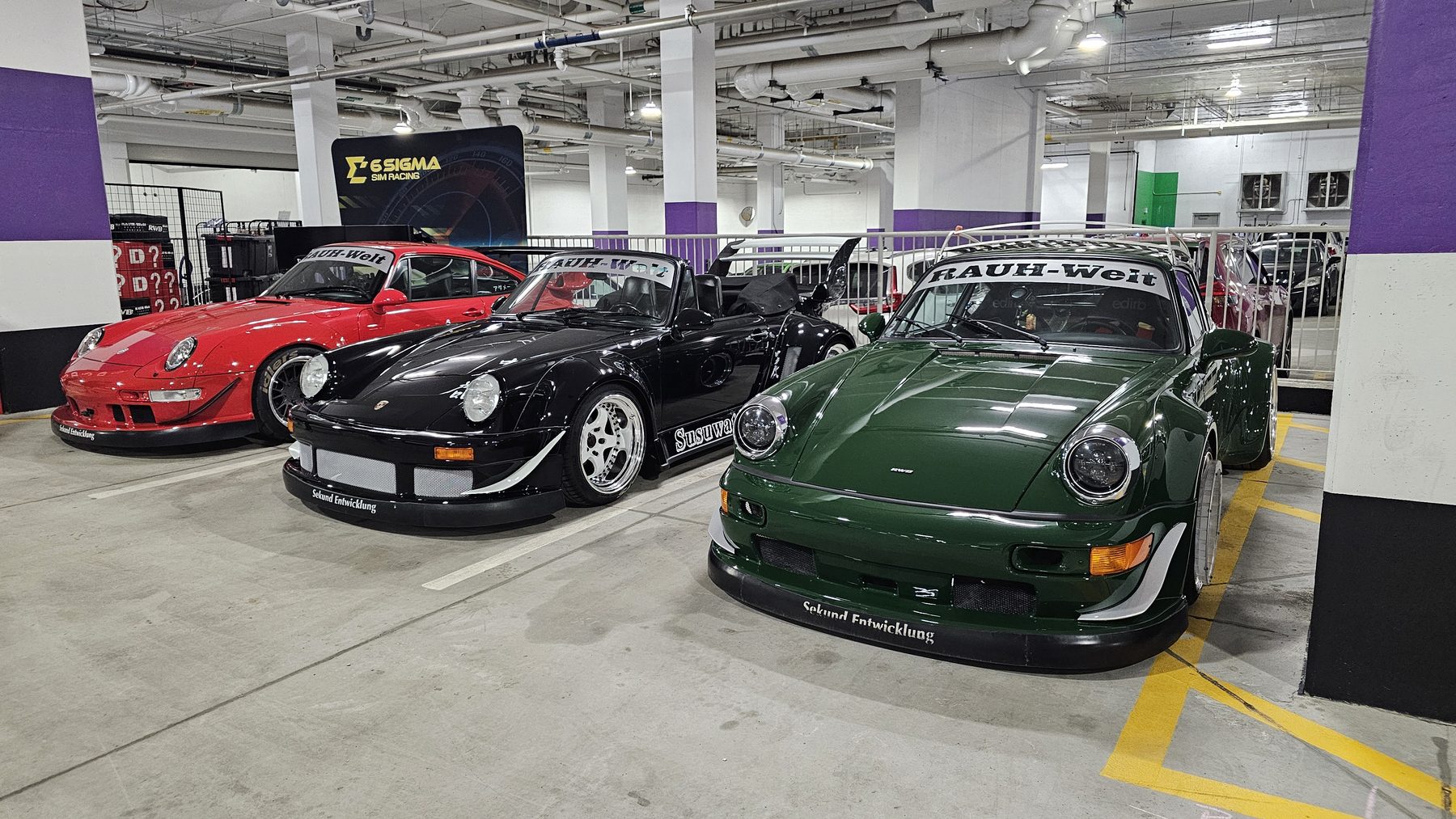 Three RAUH-Welt Begriff Porsche 964s in red, black, and dark green