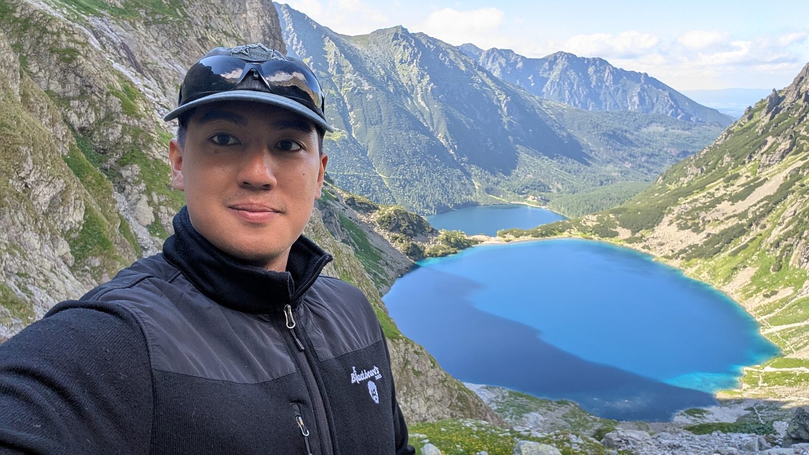 A hiker on a ridge above Morskie Oko lake in the Tatra Mountains