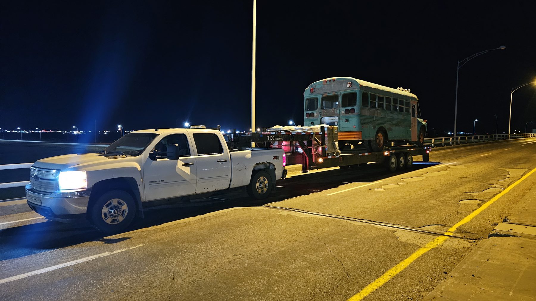 A group of snowmobilers waving in front of a snow-covered mountain