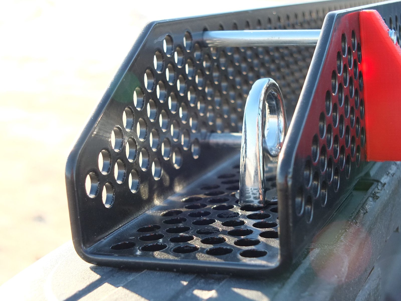 Custom-fabricated perforated steel grille with chrome hooks and red accent panels
