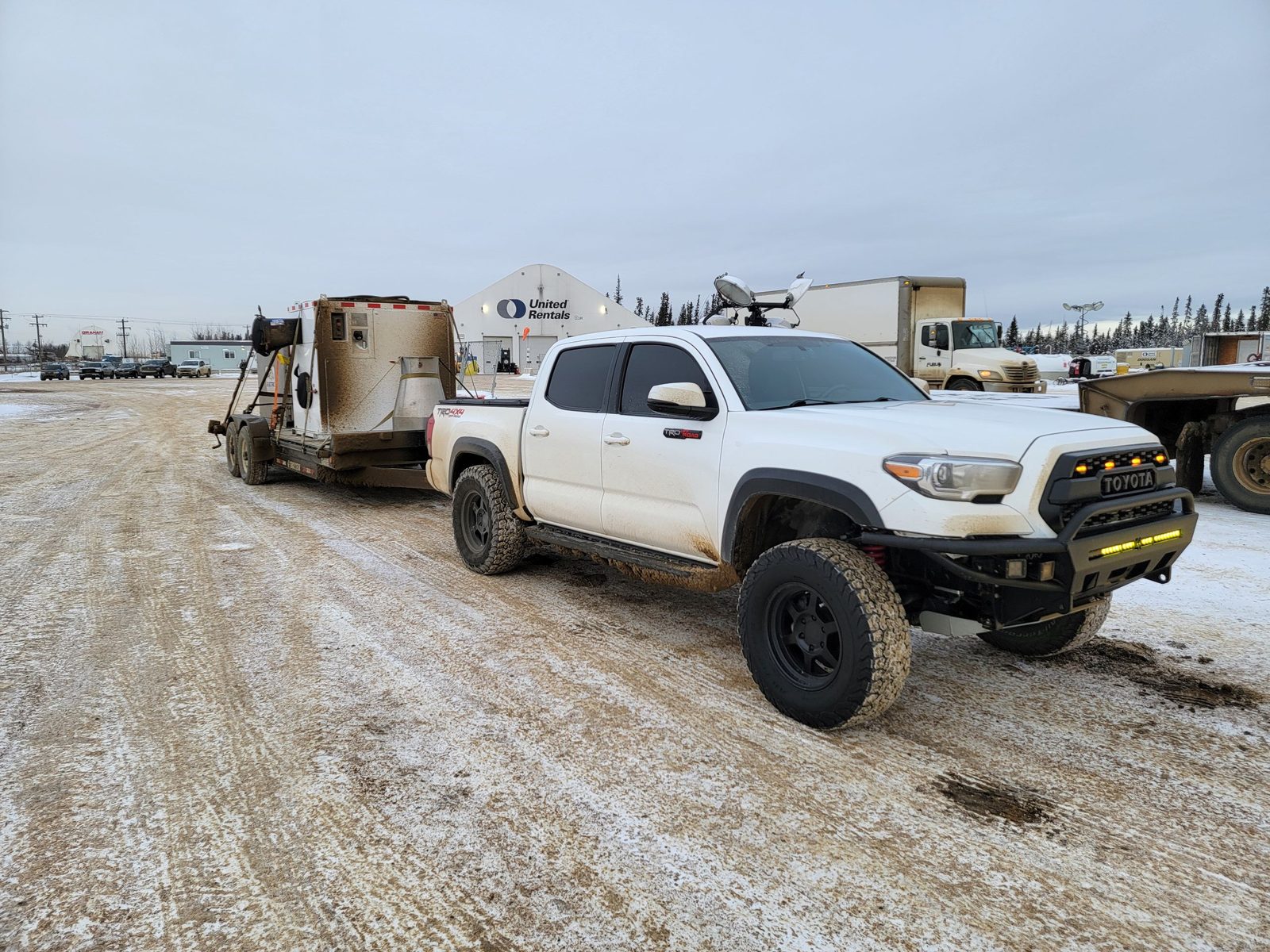 A Toyota Tacoma towing site equipment in winter